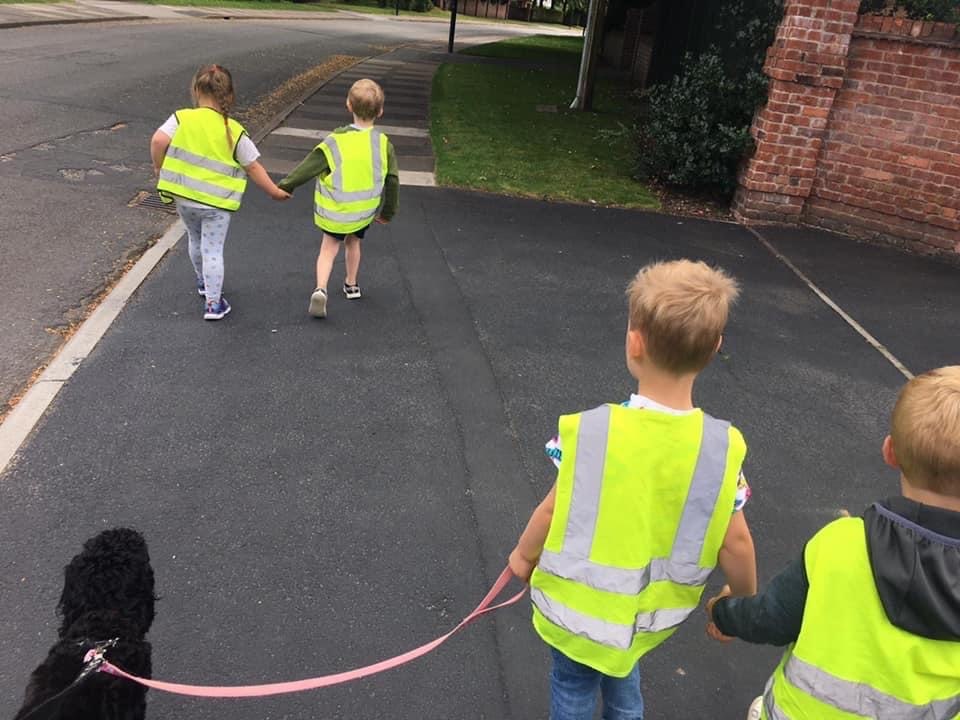 Children walking a black dog