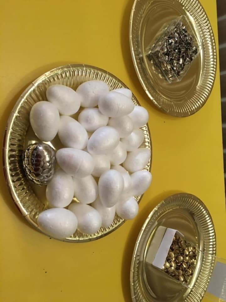 Three gold plates of decorations including decorative eggs
