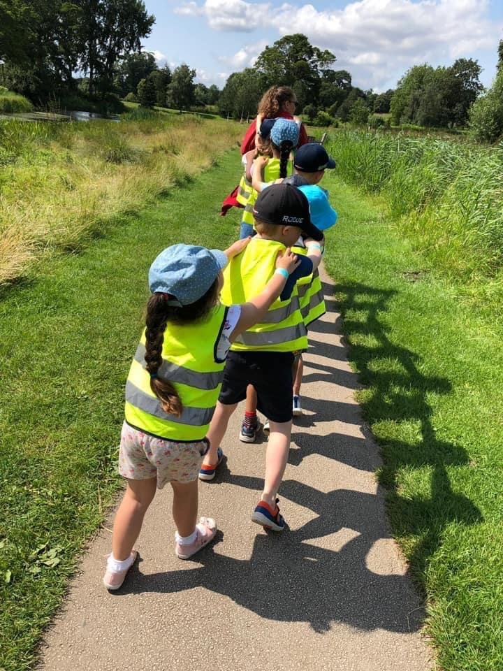Children on a walk, each child holding the shoulders of the child in front